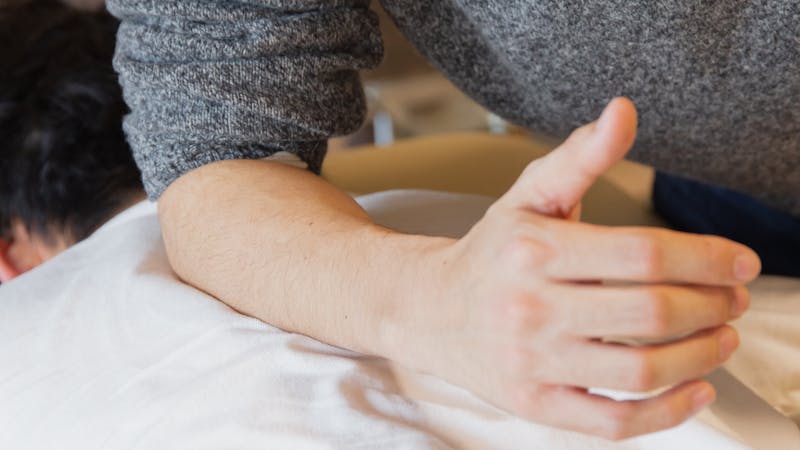 Chiropractor examining cervical spine X-ray showing curve loss