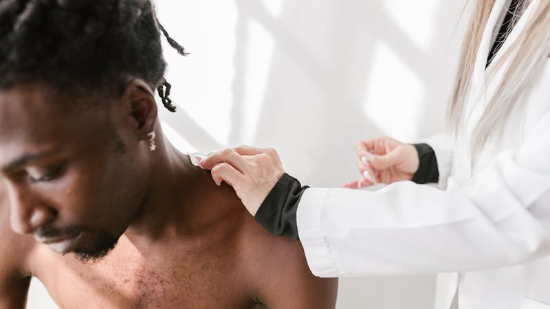 Chiropractor adjusting patient shoulder
