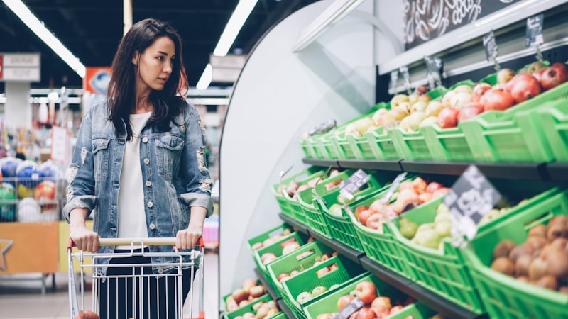 Woman shopping for fresh produce at a supermarket to reduce toxins in her diet