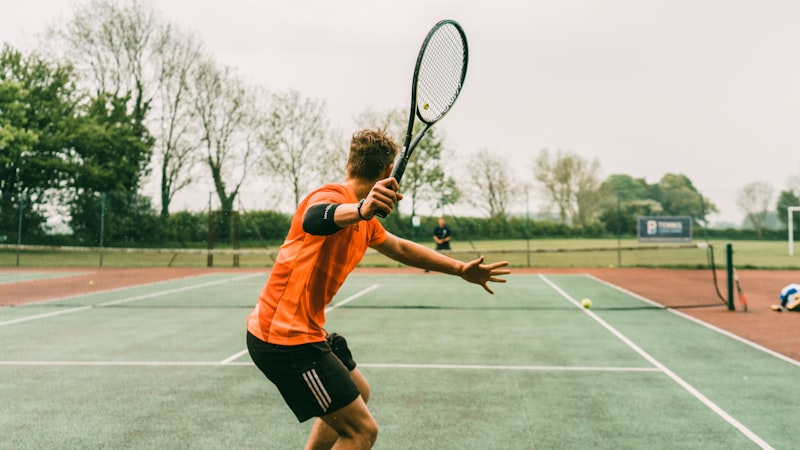 Tennis player wearing elbow brace during match on outdoor court