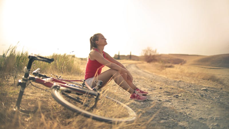 Woman relaxing outdoors in warm sunlight representing vitamin D and pain management